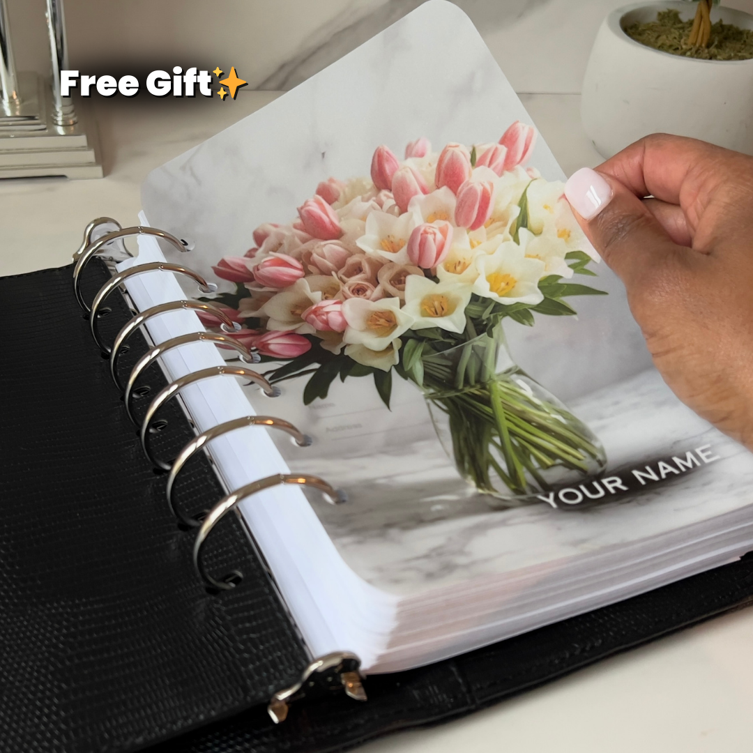 Personalized planner with floral design and 'Your Name' text, held by a hand.