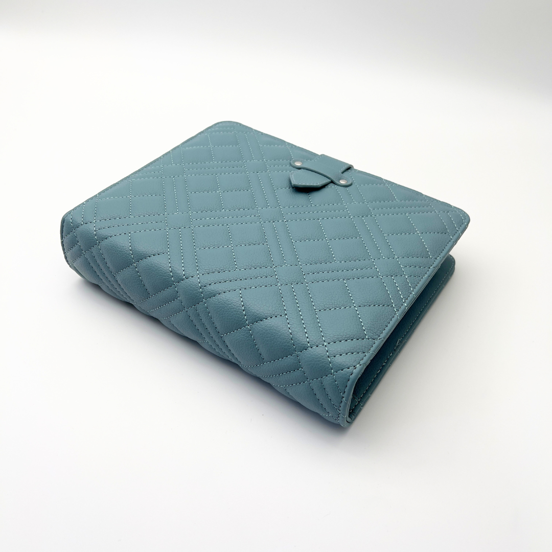 Blue genia quilted binder laying on white surface