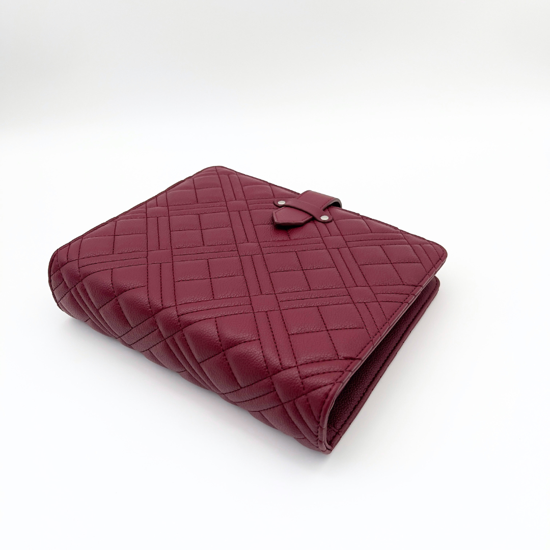 Maroon quilted clutch bag on a white background